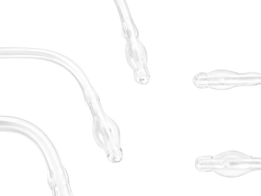Close-up of several clear plastic nasal cannula tubes with prongs and bulbous ends, arranged on a white background.
